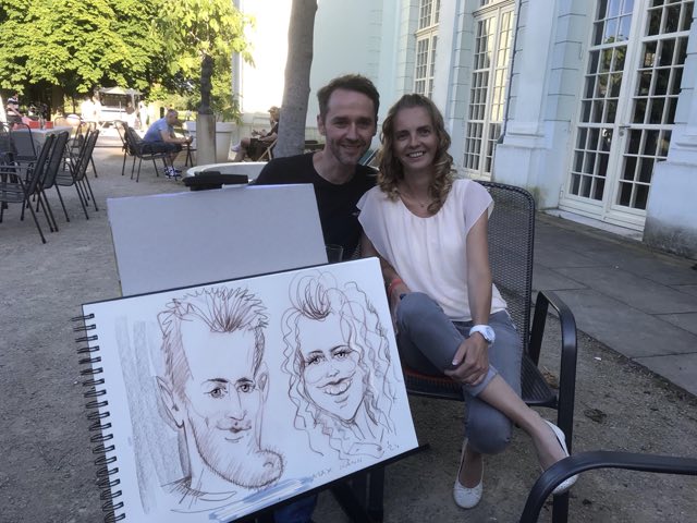 Gäste zeigen eine große Karikatur als Erinnerung an das Event